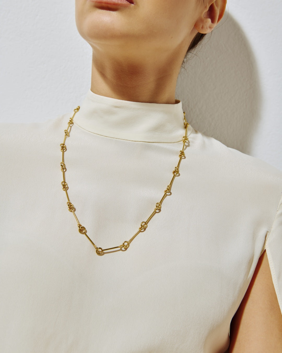 LIL Milan Magnetica 18kt gold-plated necklace worn with sleeveless white turtleneck